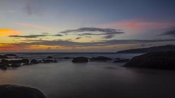 langzeitbelichtungsbild des farbenfrohen sonnenuntergangs am kamala beach in thailand im sommer foto