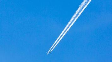 zweimotoriges Flugzeug während des Fluges in großer Höhe mit Kondensstreifen foto