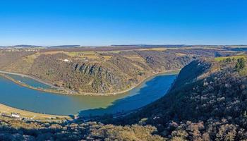 Panorama-Drohnenbild des Loreleyfelsens am Rhein, aufgenommen von der gegenüberliegenden Rheinseite bei blauem Himmel und Sonnenschein foto