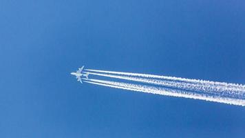 viermotoriges Flugzeug während des Fluges in großer Höhe mit Kondensstreifen foto