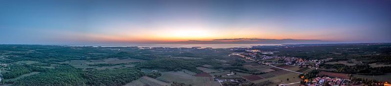 Drohnenpanorama über der istrischen Adriaküste in der Nähe von Porec, aufgenommen aus großer Höhe bei Sonnenuntergang foto