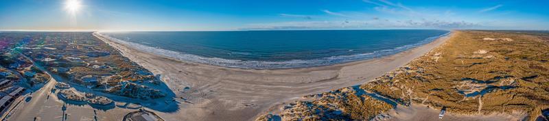 Drohnenpanorama über den Strand von Vejers in Dänemark mit Sonnenschein und Schnee foto