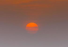 Bild eines dramatischen und farbenfrohen Himmels mit Sonne während des Sonnenuntergangs foto