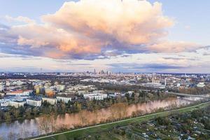 luftpanoramabild des mains und der frankfurter skyline bei sonnenuntergang im abendrot mit beleuchteter wolke foto