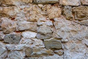 Nahaufnahme einer alten Natursteinmauer mit typischer Textur foto