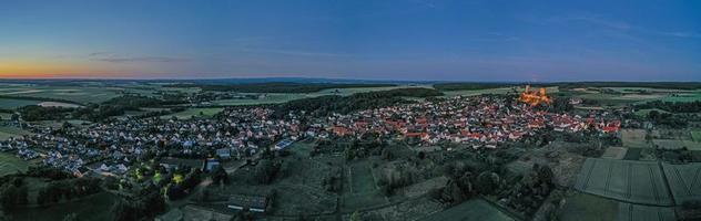 Drohnenbild von Münzenberg mit beleuchteter Burgruine in Deutschland foto