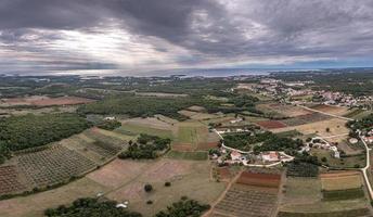 Drohnenpanorama über der istrischen Adriaküste in der Nähe von Porec, aufgenommen aus großer Höhe tagsüber mit bewölktem Himmel und beeindruckenden Sonnenstrahlen foto