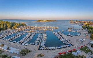 Drohnenpanorama der kroatischen Küstenstadt Porec mit Hafen und Promenade bei Sonnenaufgang foto