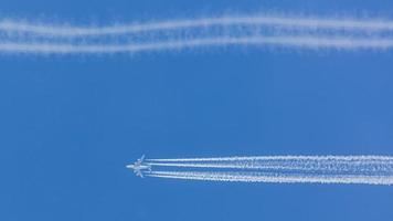 viermotoriges Flugzeug während des Fluges in großer Höhe mit Kondensstreifen foto