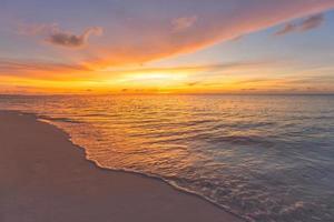 Sonnenuntergang Meereslandschaft. bunter ozeanstrand sonnenaufgang. wunderschöne Strandlandschaft mit ruhigen Wellen und weichem Sandstrand. leere tropische landschaft, horizont mit malerischem küstenblick. bunter naturseehimmel foto