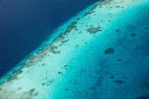 luftaufnahme des malediven-resorts, luxusreiseziel. vogelperspektive auf tiefblaues meer, korallenschilf, tropische insel. erstaunliche naturansicht, drohnenluftlandschaft foto