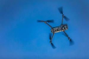 drohne fliegt gegen blauen himmel mit kopierraum. moderne technologie uav mit kameranutzung für foto oder video