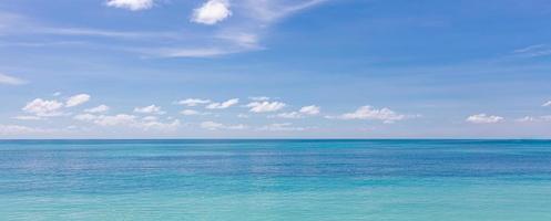 türkisfarbenes Wasser und blauer Himmel als Hintergrundbild. karibisches meerpanorama, malediveninseln, hawaii, thailändisches ozeanwasser, türkisfarbene tropische paradiesinsel. Panorama der Meereswellen. friedliche Natur foto