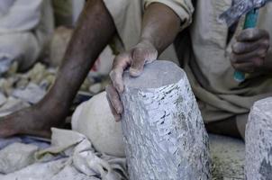 Hände eines männlichen ägyptischen Bildhauers bei der Arbeit mit einem Steinalabaster foto