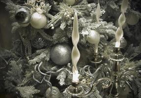 Luxuriöser, silberglänzender Christbaumschmuck mit eleganten weißen Kerzen foto