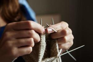 Frau strickt Socken mit Nadeln foto