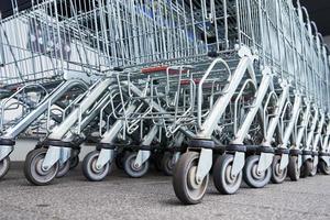 Viele leere Einkaufswagen auf dem Ladenparkplatz foto