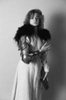 hübsche Frau mit Metallhandschuh in antiker Kleidung monochromes Porträtbild foto