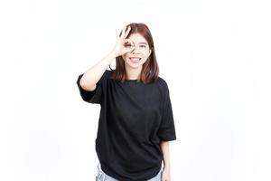 lächelnd und zeigt ok Zeichen der schönen asiatischen Frau isoliert auf weißem Hintergrund foto