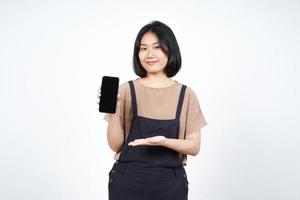 Anzeigen von Apps oder Anzeigen auf dem Smartphone mit leerem Bildschirm einer schönen Asiatin, die auf weißem Hintergrund isoliert ist foto