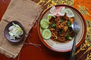 mie tek tek oder gebratene Nudeln aus Eiernudeln mit Huhn, Kohl, Senf, Fleischbällchen, Rührei. indonesisches essen foto