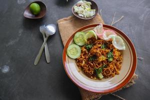 mie tek tek oder gebratene Nudeln aus Eiernudeln mit Huhn, Kohl, Senf, Fleischbällchen, Rührei. indonesisches essen foto