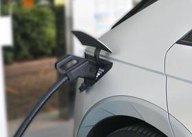 ev auto oder elektroauto an ladestation mit eingestecktem stromkabel foto