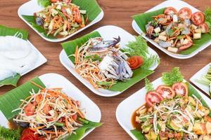 Set aus mehreren Papayasalaten und würzigem Salat auf dem Tisch. Food-Konzept im thailändischen Stil foto