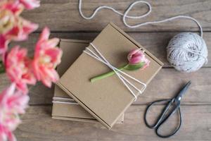 mit Blumen geschmückte Geschenkboxen aus Kraftpapier. Vorbereitung von Geschenken. geschenkverpackung idee foto