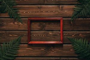 Farnblätter auf dunklem Holzhintergrund mit Rahmen foto