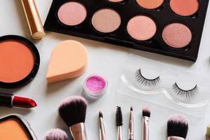 make-up und pinsel draufsicht weißer tisch. Arbeitsplatz für Frauen. foto