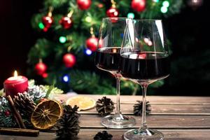 Gläser Wein auf dem Hintergrund eines geschmückten Weihnachtsbaums. Neujahrsstimmung foto