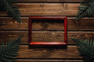 Farnblätter auf dunklem Holzhintergrund mit Rahmen foto