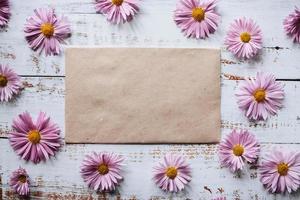 schöne rosa Chrysanthemenblumen auf weißem Hintergrund mit Postkarte foto