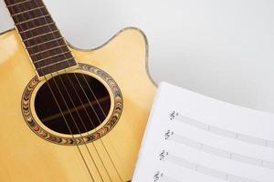 Akustikgitarre mit Musiknoten auf weißem Hintergrund. liebe, musik und lernkonzept. foto