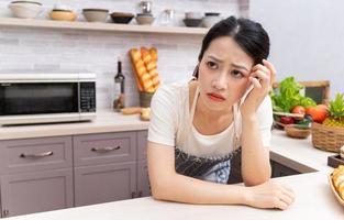 junge asiatische frau, die sich von der hausarbeit müde fühlt foto