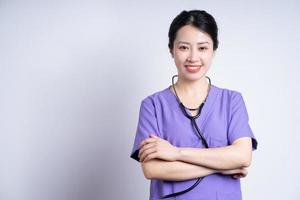 Porträt der jungen asiatischen Krankenschwester auf weißem Hintergrund foto