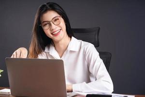 Bild der jungen asiatischen Geschäftsfrau, die im Büro arbeitet foto