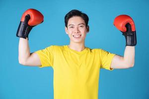 Foto eines jungen asiatischen Mannes mit Boxhandschuh