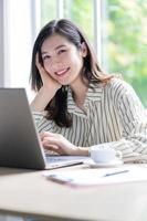 Bild der jungen asiatischen Geschäftsfrau, die im Büro arbeitet foto