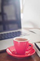 rote Kaffeetasse und Laptop foto