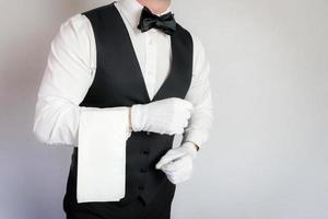 Porträt eines sauberen und eleganten Kellners oder Butlers auf weißem Hintergrund. kopierraum für die servicebranche und professionelle höflichkeit. foto