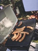 Frische Wurst und Hotdogs grillen im Freien. Konzept-Picknick foto