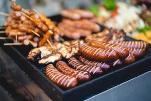 leckere Grillwürste mit Salat und Gemüse foto