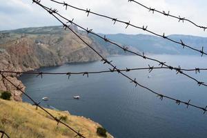 militärische Grenze aus Stacheldraht auf See in den Bergen foto