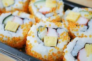 Detailaufnahme einer Sushi-Rolle mit Lachs, Garnelen und Avocado foto