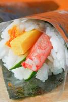 Essstäbchen mit Sushi-Rolle mit Lachs, Garnelen und Avocado foto