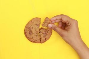 Draufsicht auf das Brechen von süßen Keksen auf gelbem Hintergrund foto