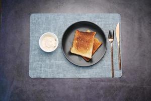 Draufsicht auf Milchcreme in einem Behälter und Brot in einem Teller foto