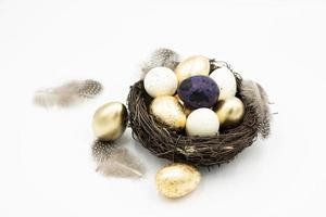 nest, goldene und weiße ostereier foto